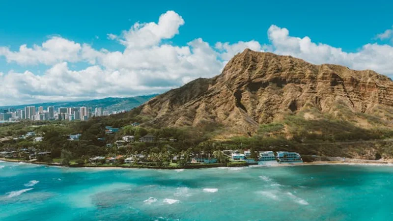 Hawaiian coastline with turquoise water, palm trees and a volcanic backdrop