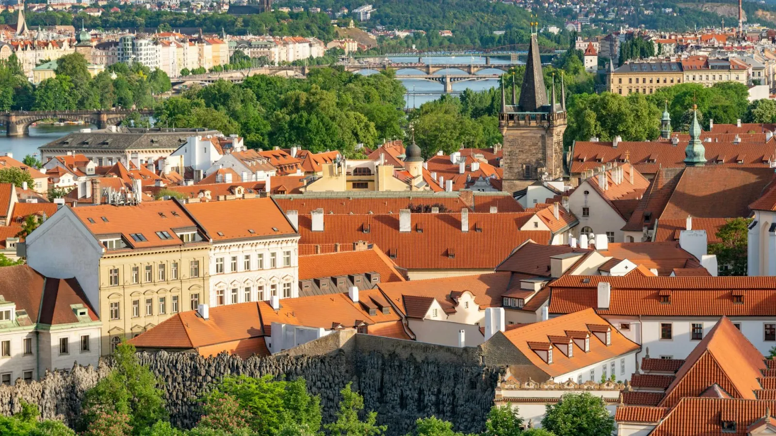 Prague panoramic view with red rooftops and gothic castle on hill at dusk