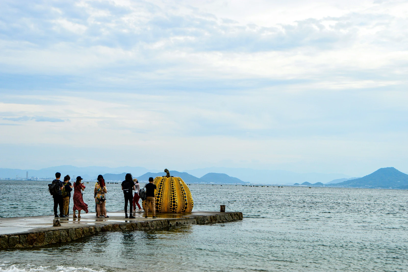 Yayoi Kusama's yellow pumpkin sculpture on a pier overlooking the Seto Inland Sea on Naoshima art island, Japan