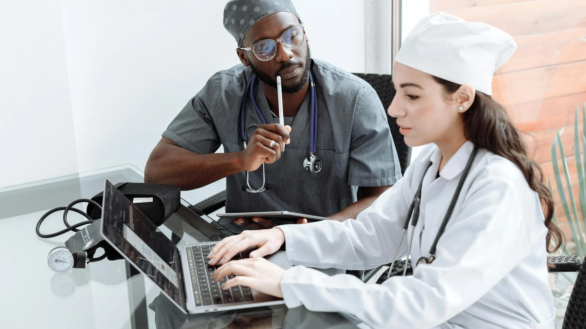 Nurse reviewing financial documents and pay stub at home office desk